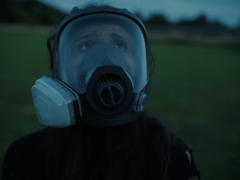 Littermates film still showing Mel in a respirator outdoors